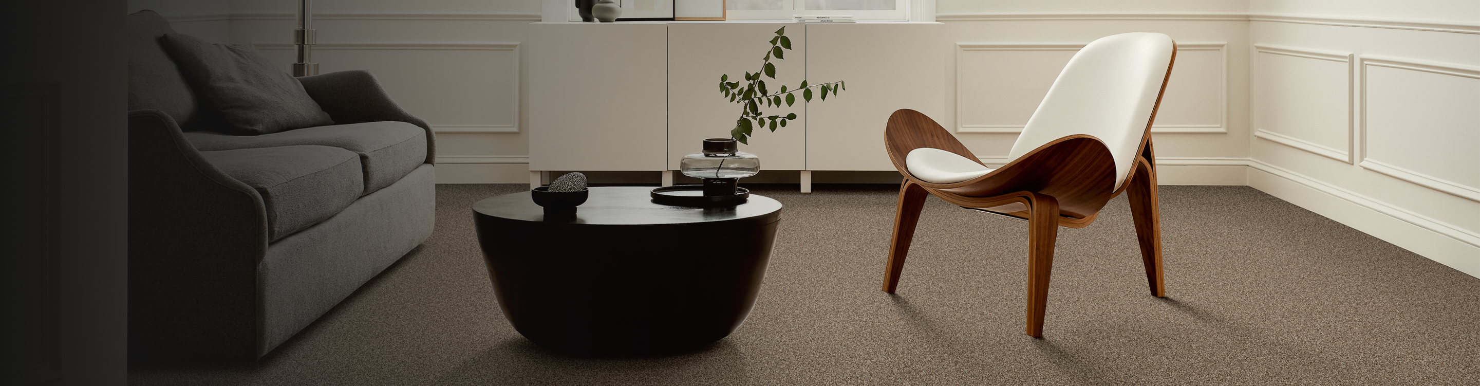 Living room with brown carpet with a modern accent chair