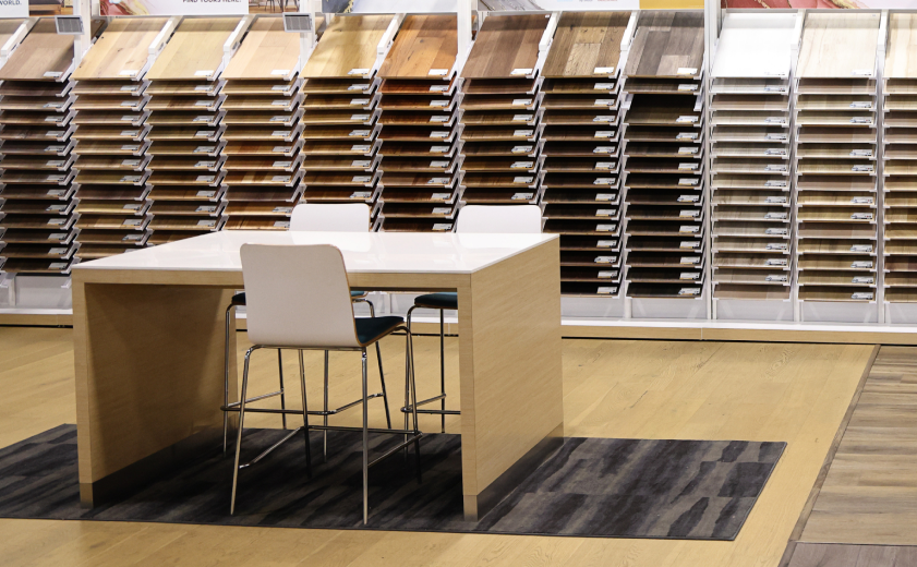 Flooring showroom with organized sample displays and a consultation table